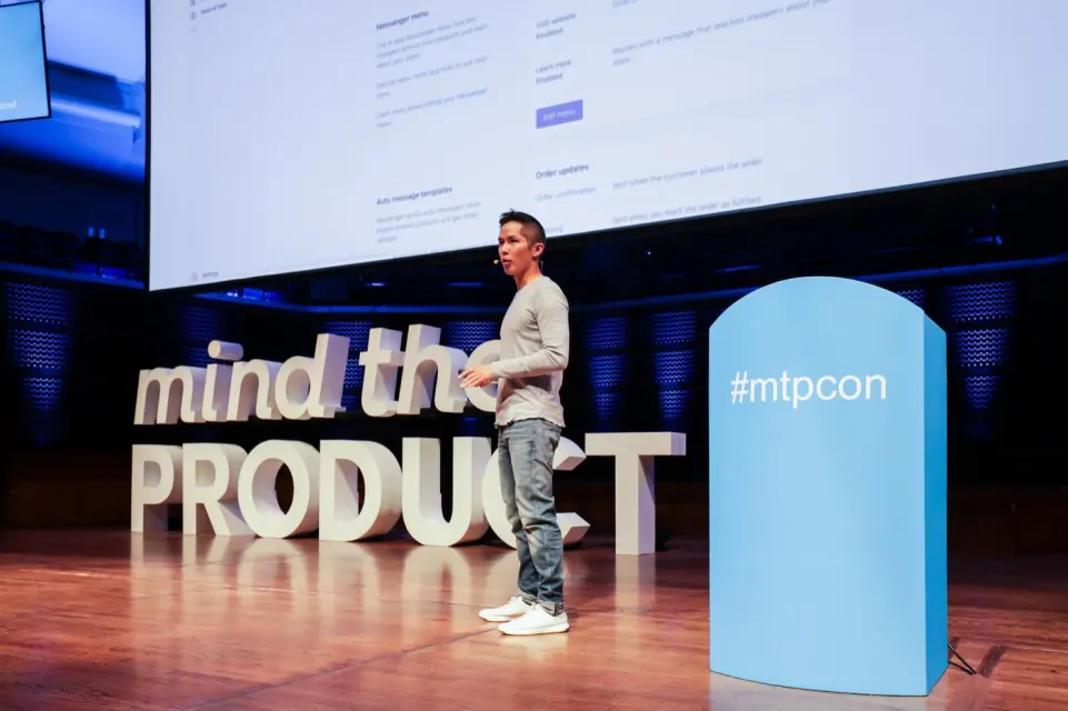 Brandon on stage in front of large Mind the Product letters